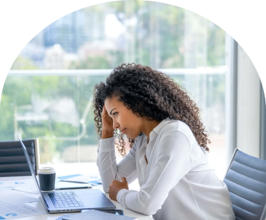 Woman stressed at laptop in office.
